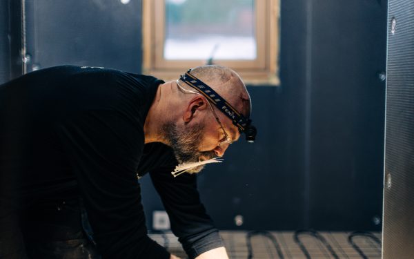 elektriker vidar schau fra e-verket monterer varmekabler med hodelykt på